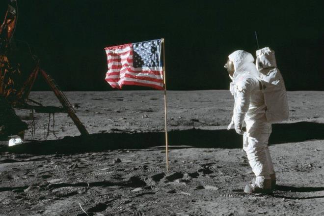 Phi hành gia Buzz Aldrin đứng cạnh lá quốc kỳ Mỹ đầu tiên được cắm trên bề mặt Mặt trăng năm 1969.